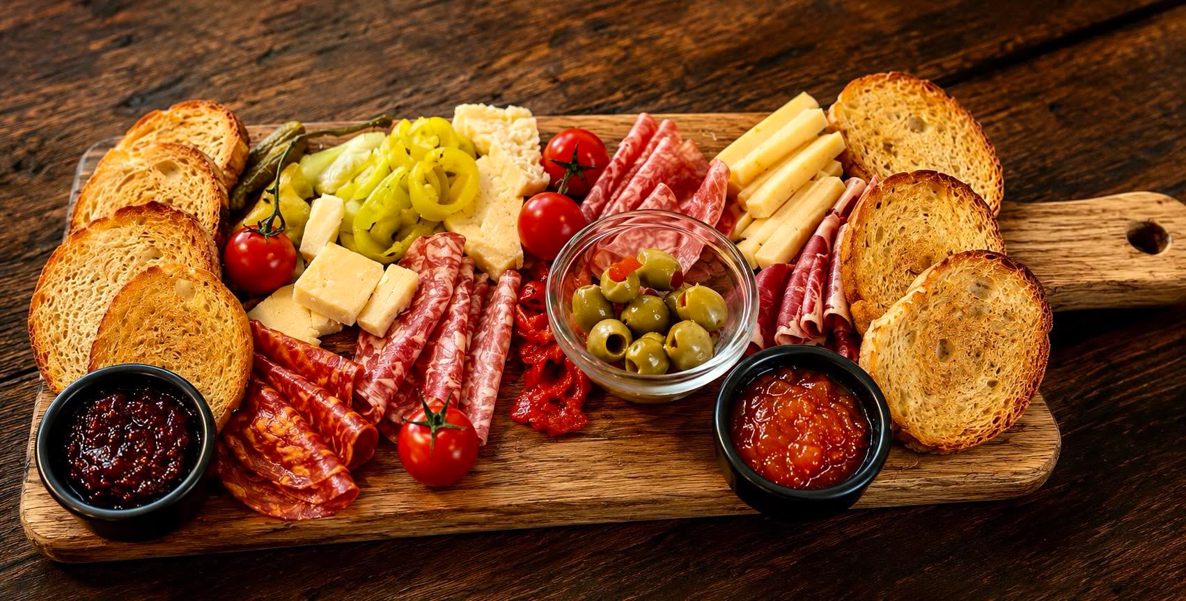 Charcuterie board with cured meats, cheeses, olives and toasted bread