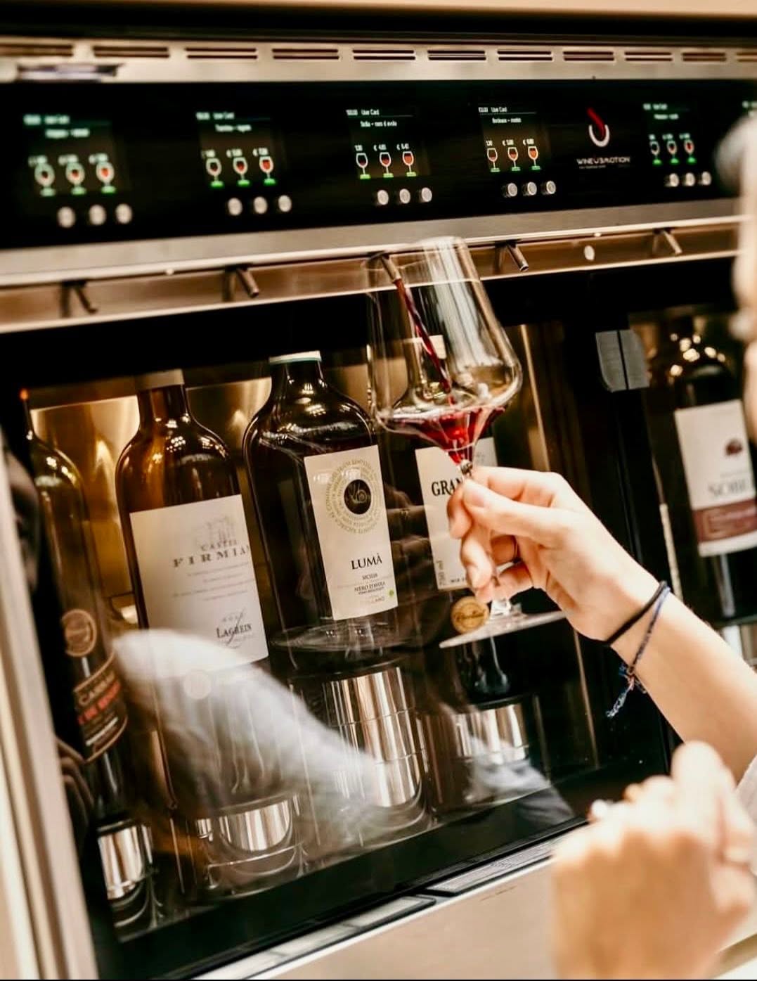 Red wine pouring into a glass from the automated wine-tasting dispenser